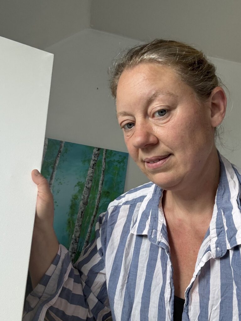 Artist Bodil Greiner holding a blank canvas for a custom acrylic painting commission.